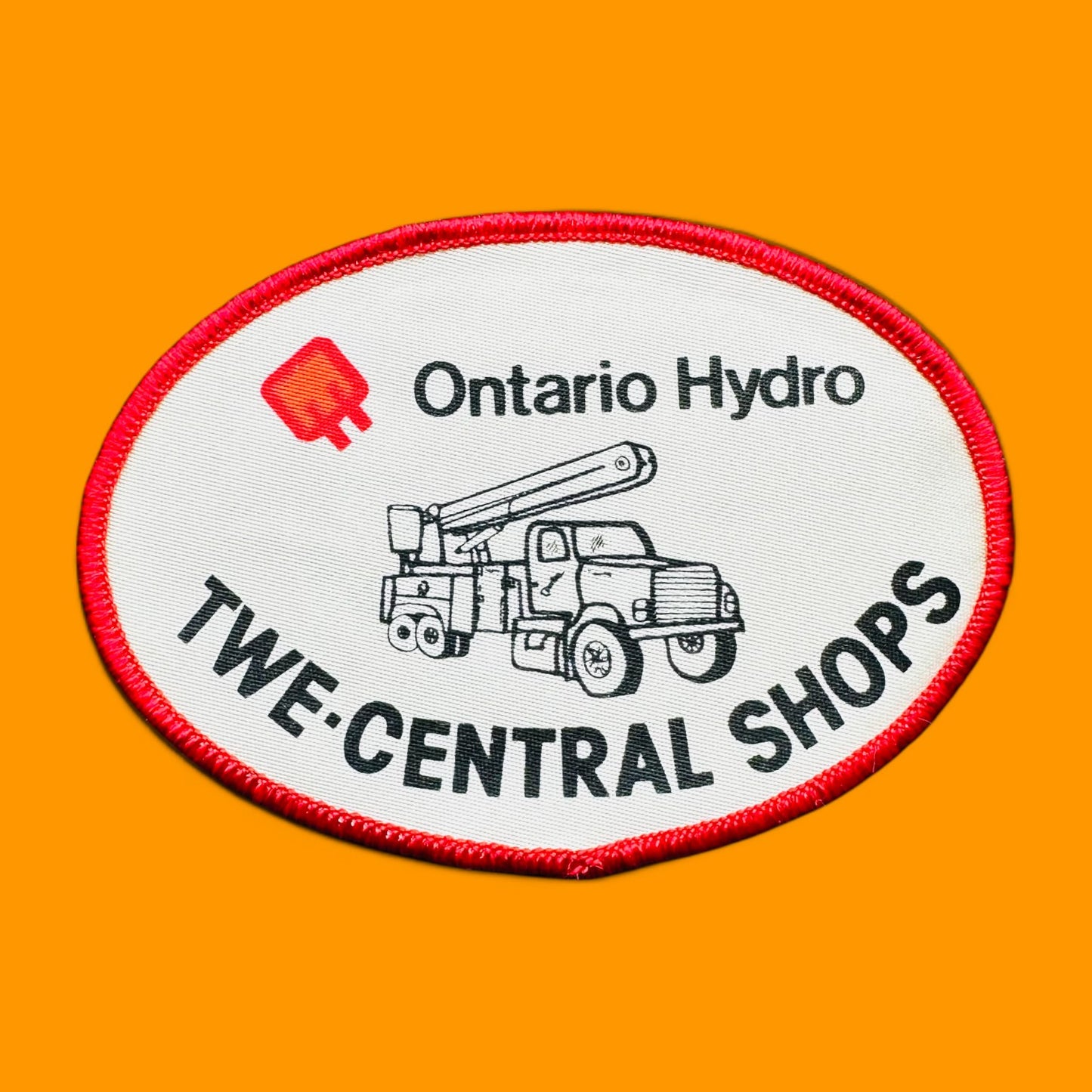Ontario Hydro TWE-Central Shops Embroidered Patch 3" x 4" Oval Sew On features a white background with vibrant red trim.
