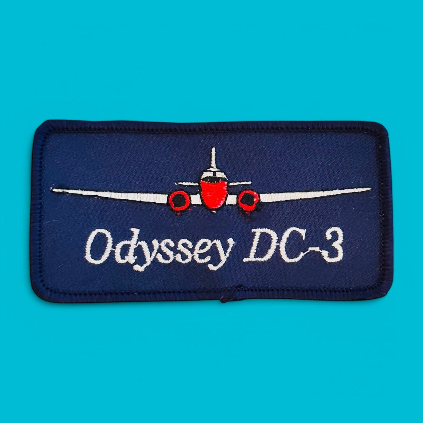 DC-3 Odyssey Embroidered Patch - Vintage NOS features an aircraft design on a blue background, perfect for collectors.