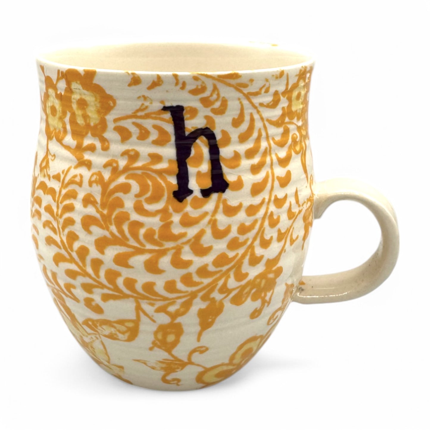 Curved Anthropologie Mug with Initial H in floral beige, yellow, and brown; features Chinios design and light crazing.