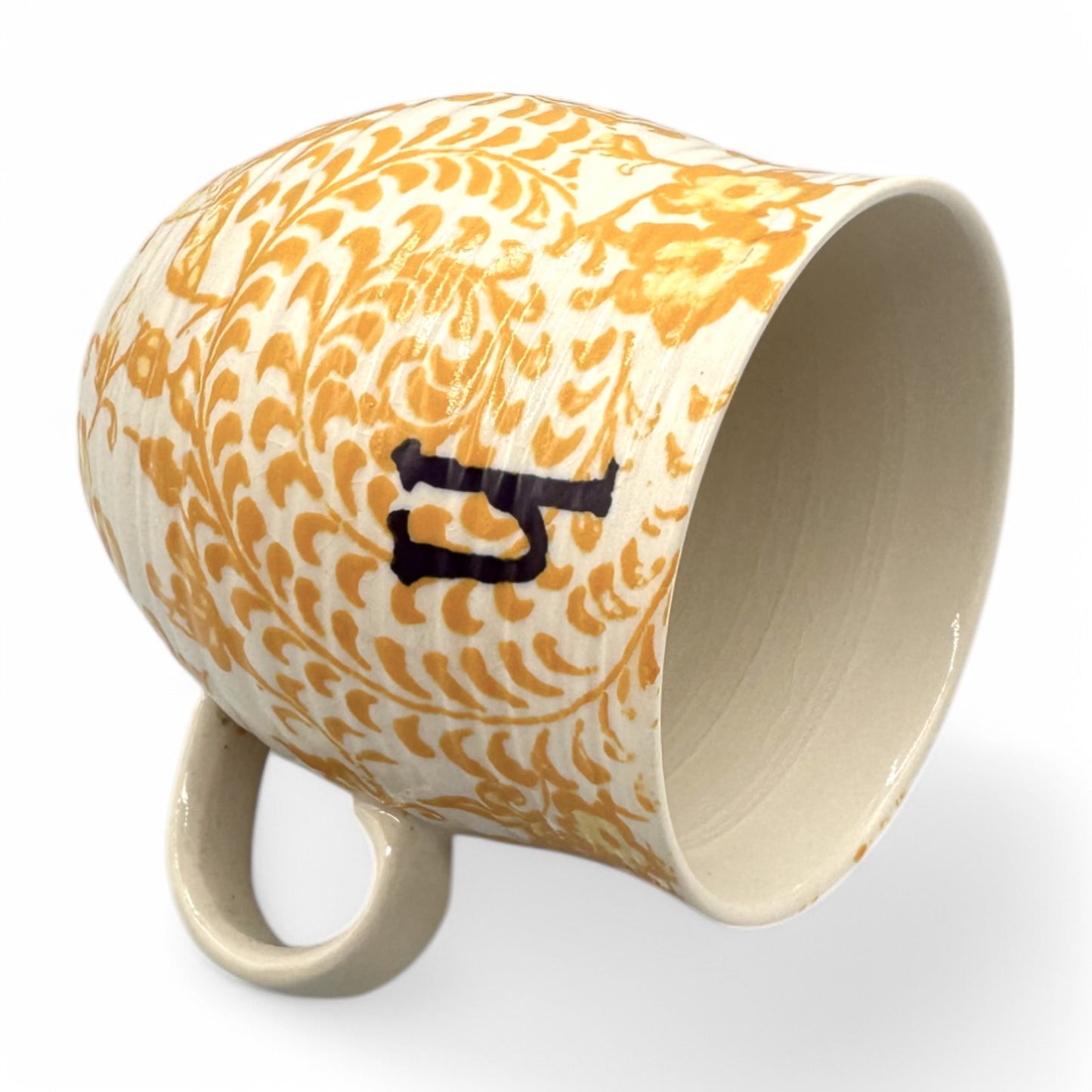 Curved Anthropologie mug with Initial H, floral design in beige, yellow, and brown, featuring light crazing.