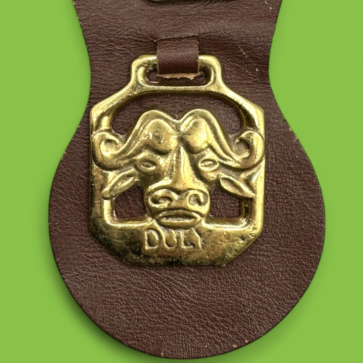 Brass horse adornment on leather strap showcasing African animals: water buffalo, elephant, antelope, gazelle.