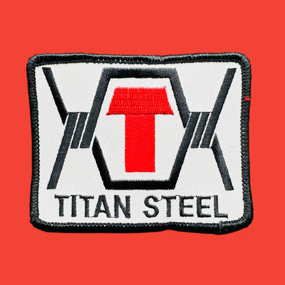 Vintage 1990's Titan Steel Embroidered Patch featuring a red "T" on a white background with black edging.