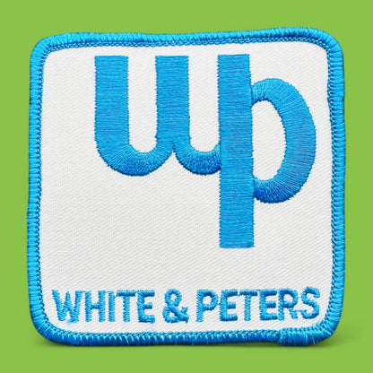 White & Peters c patch featuring baby blue embroidery on a white background, perfect for vintage enthusiasts.