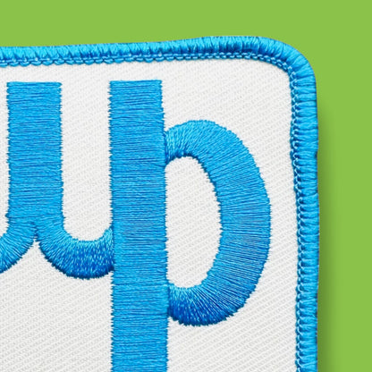 Embroidered patch "c" on a white background with baby blue text and trim, perfect for vintage styling.
